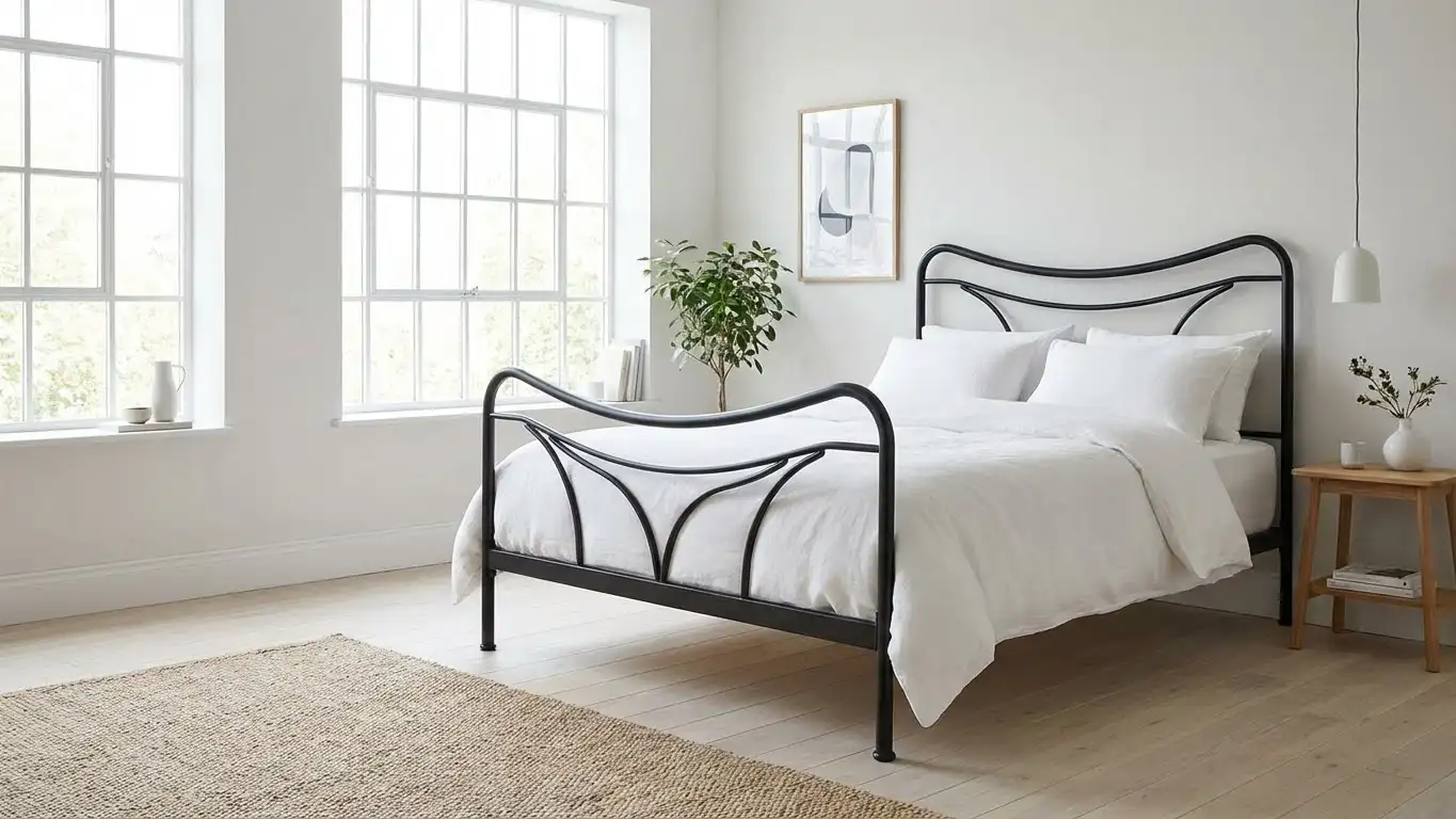 Beautiful Scandinavian iron bed (jernsenger) in a modern Nordic bedroom with white linens and minimalist decor